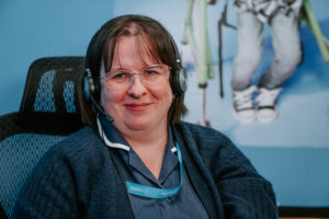 female nurse wearing a telephone headset smiling