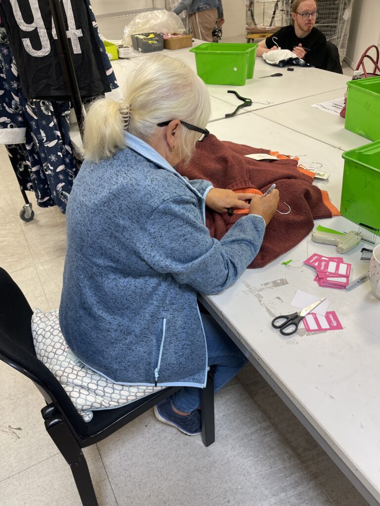 Woman volunteer sat with other volunteers around a table working