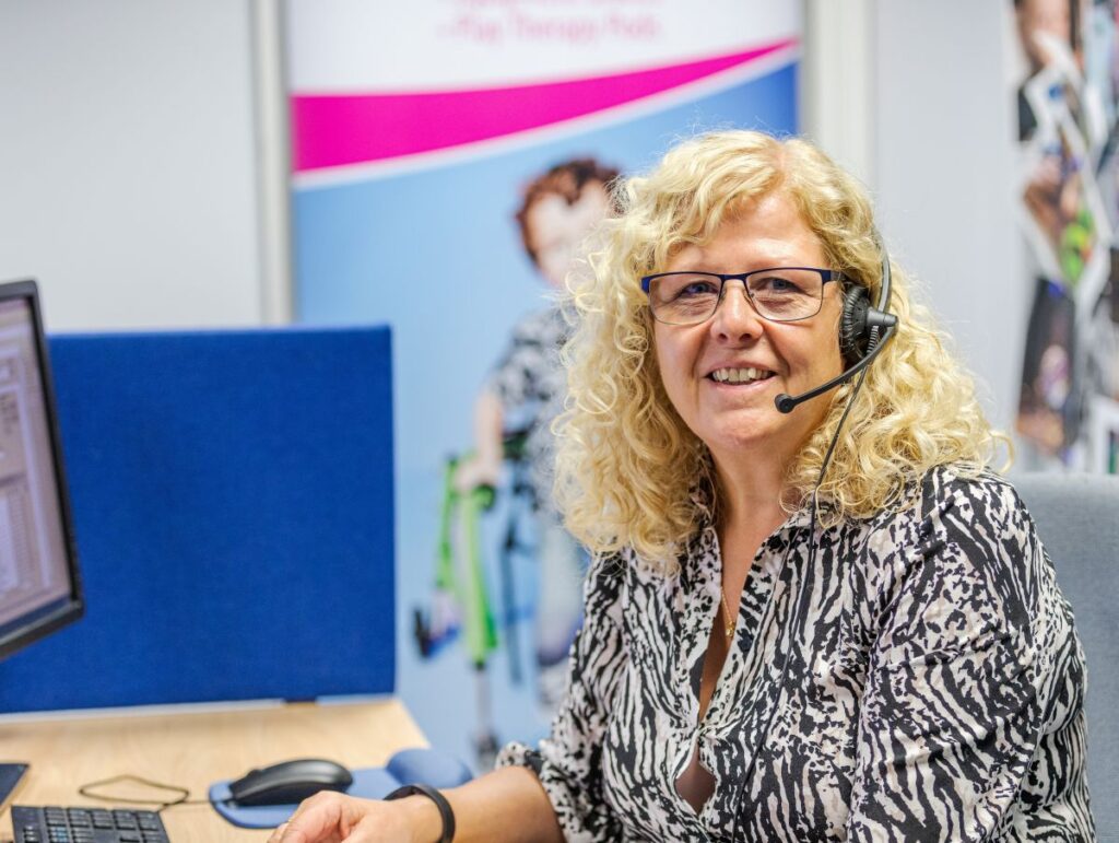 Karen wearing a headset sat at a desk