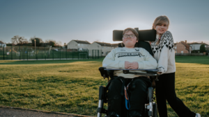 Picture of Laigan with her sister in the new powered wheelchair funded by Newlife