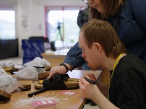 volunteer being shown what to do by a female employee