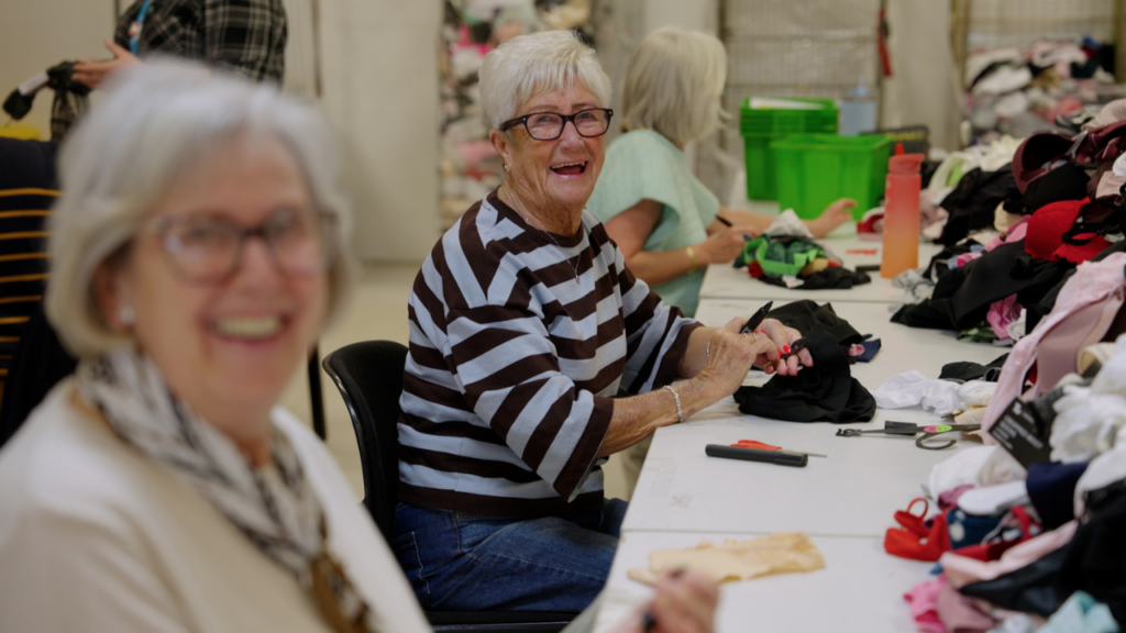Picture shows two Newlife volunteers processing stock in the Newlife opportunities centre. Sat at a table.