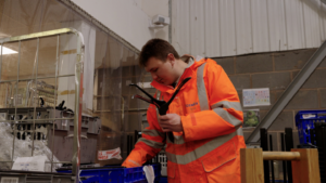 Picture shows a Newlife warehouse volunteer sorting coathangers in the warehouse